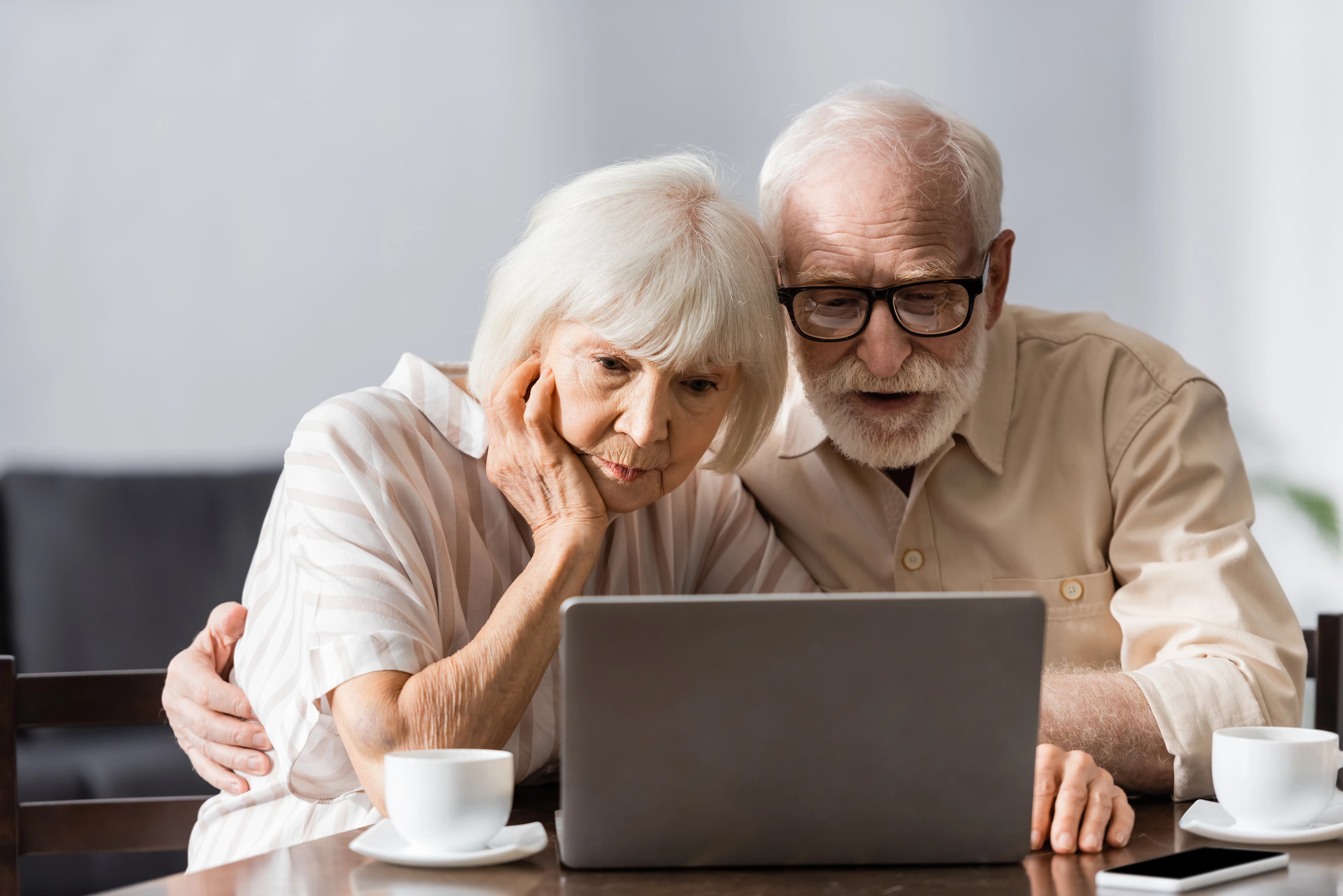 An older couple looking at a laptop together while planning their next step